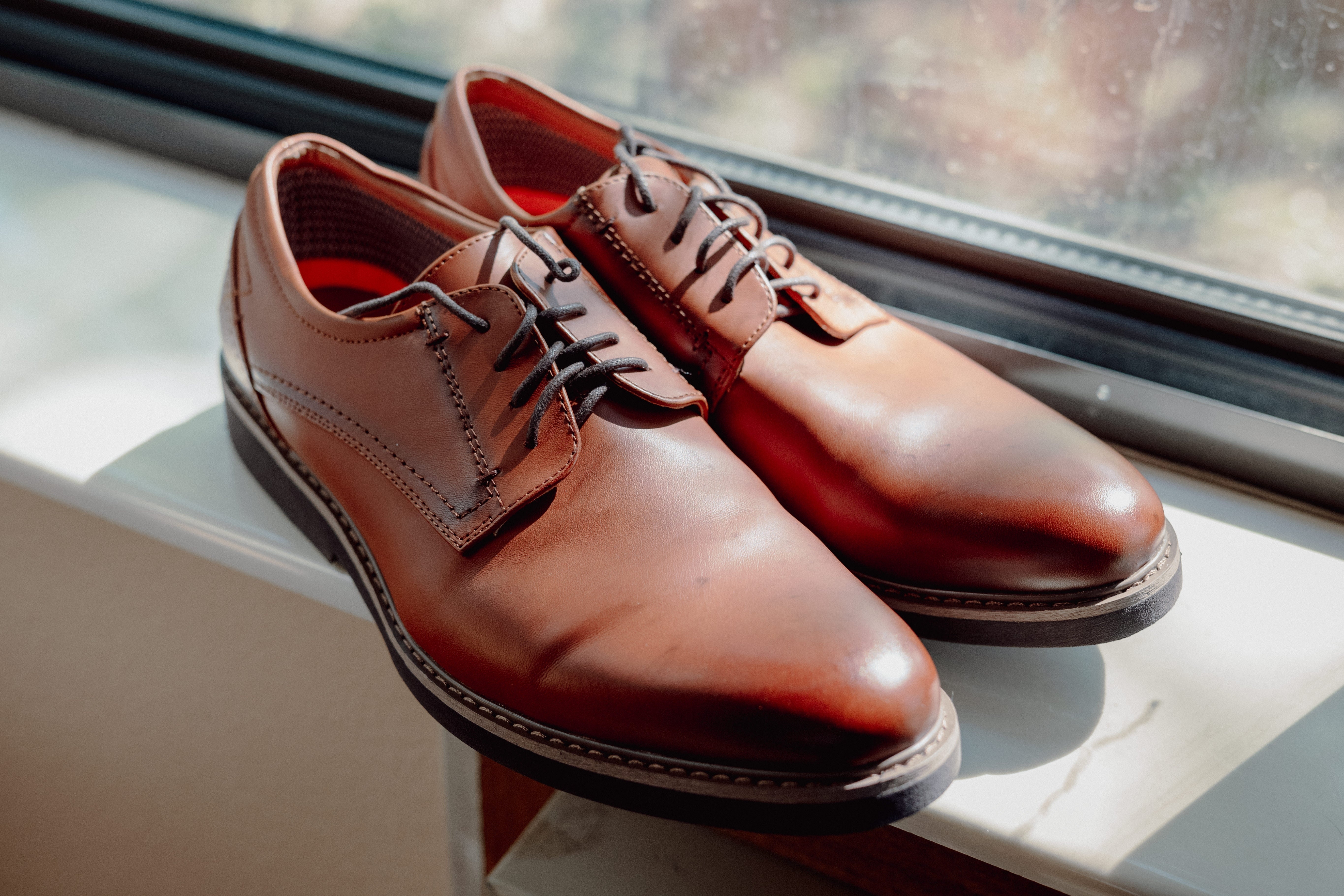 A pair of brown men's dress shoes in extended size, showcasing stylish and contemporary design.