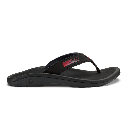 OluKai ‘Ohana sandals in black with red details, featuring a durable water-resistant strap and cushioned footbed, side view.