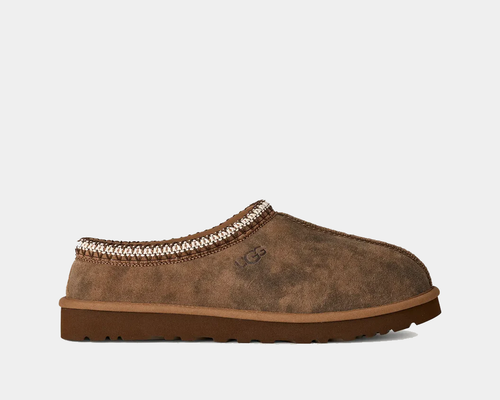 Brown suede slipper with decorative trim on a white background