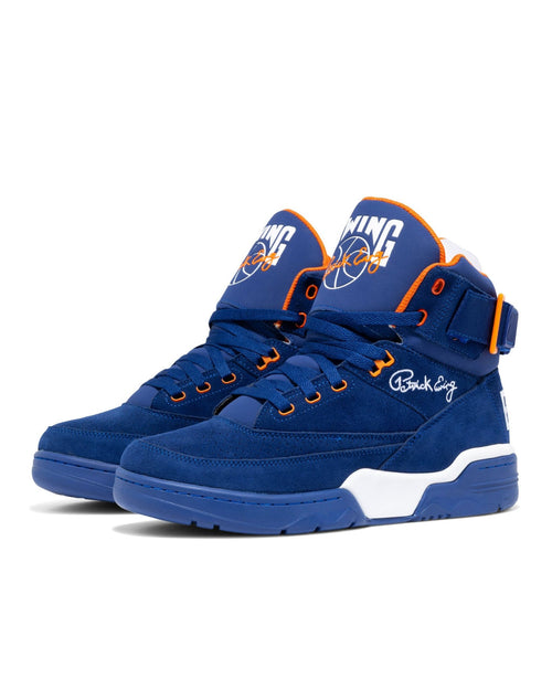 Ewing Athletics 33 HI OG sneakers in royal blue suede with orange and white accents, mid-top design, front side angle.