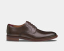 Johnston & Murphy Conard 2.0 Plain Toe dress shoes in dark brown leather with brogue detailing and woodgrain sole, side view.