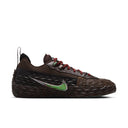 A Nike sneaker in dark brown with a textured, woven-look upper and sole, featuring red laces and a green and silver Swoosh logo on the side, set against a plain white background.