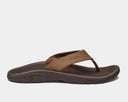 A pair of brown Ohana sandals by Olukai, featuring a water-resistant synthetic strap and a non-marking rubber outsole with a coral reef lug design.
