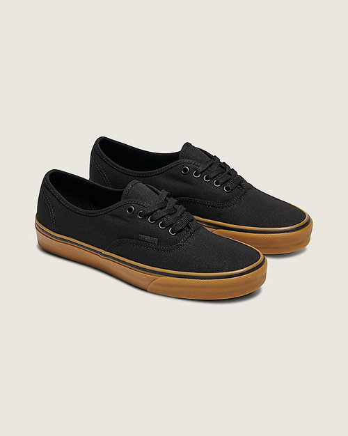 Vans Gum Authentic sneakers in black canvas with gum rubber sole and metal eyelets, angled front side view.