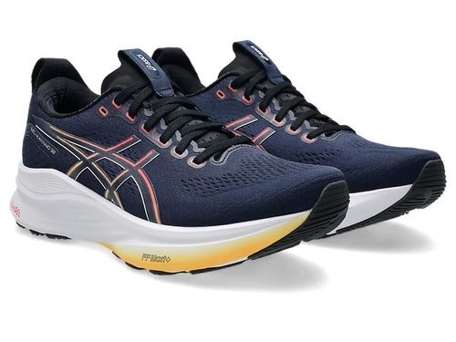 Navy running shoes with white soles on a white background