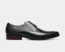 Florsheim Postino Cap Toe Oxford dress shoes in black leather with textured side panels and wooden heel, side view.